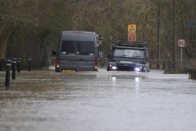 A car drives past a van stranded in floodwater in Yalding, Kent