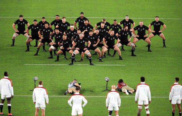 England's players stare down New Zealand's haka in a V formation
