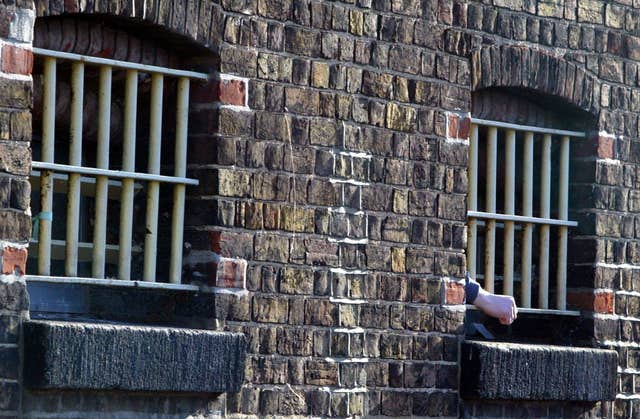 A prisoners hand pokes through bars (Andrew Parsons/PA)