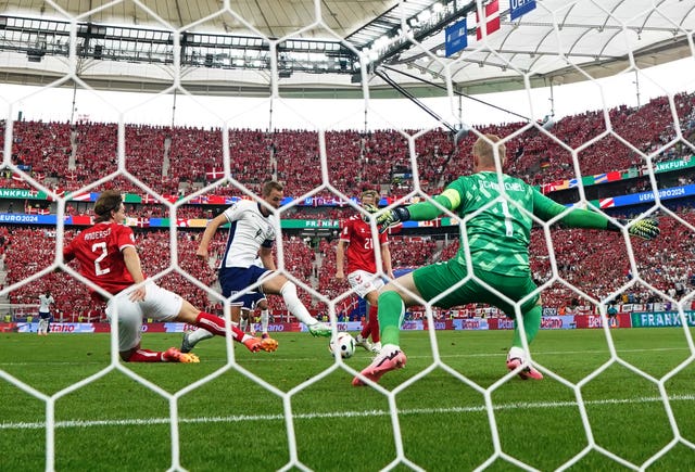 Harry Kane slots the ball into the Denmark goal with his left foot