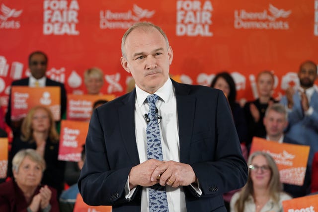 Sir Ed Davey speaking in front of supporters and Lib Dem signage