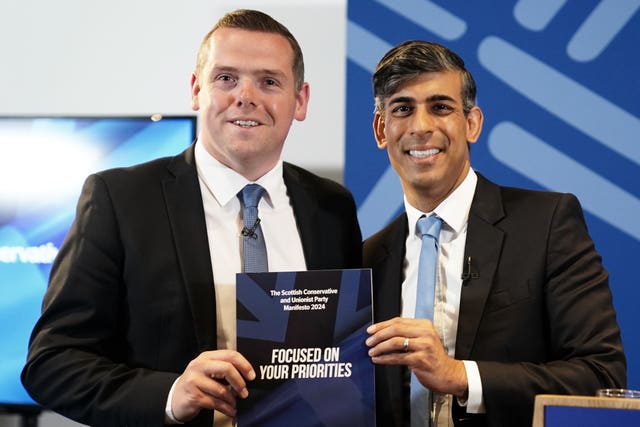 Scottish Conservative leader Douglas Ross and Prime Minister Rishi Sunak holding a copy of the party's manifesto
