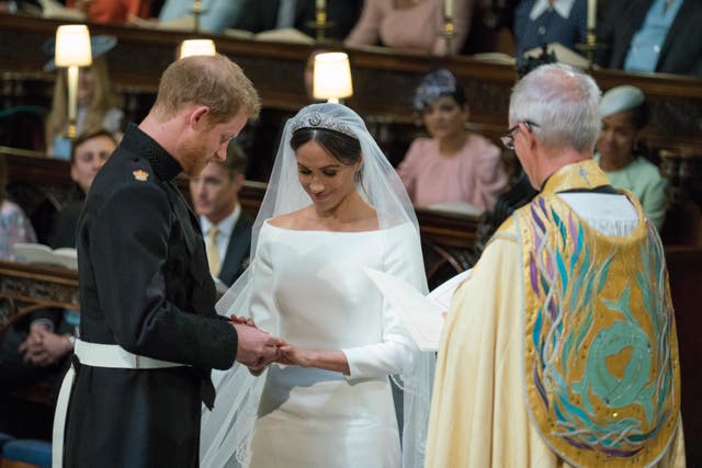 Harry places the wedding ring on Meghan’s finger during their wedding at St George’s Chapel at Windsor Castle. Dominic Lipinski/PA Wire