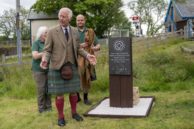 Charles, wearing a kilt, unveils the Flow Country World Heritage Site plaque