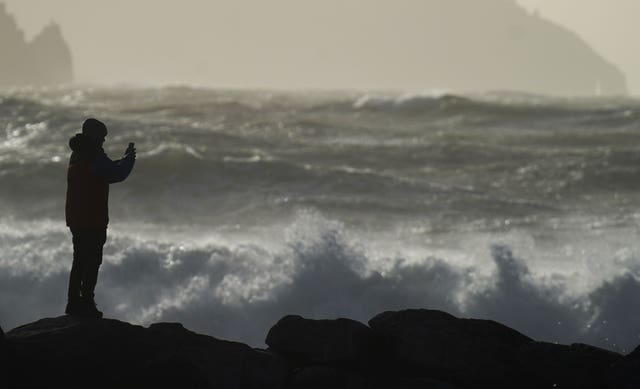 A person watching high waves in Doolin in County Clare