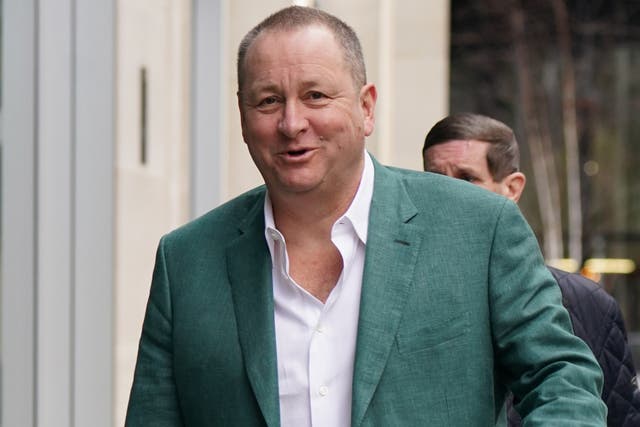Mike Ashley wearing a green suit and white shirt
