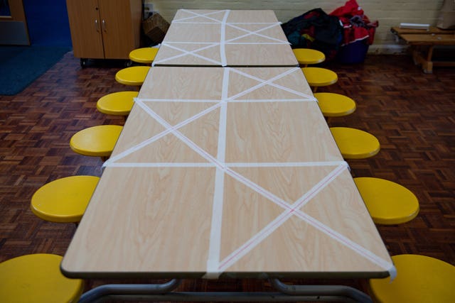 Tables are marked showing where children can sit during dinner time at a primary School in Worcester (Jacob King/PA)