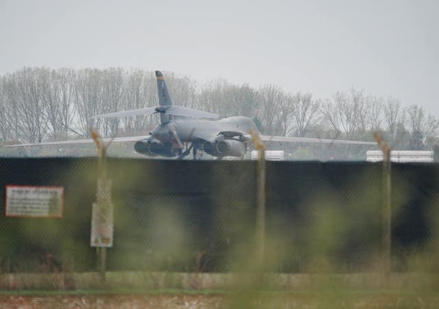 A plane on the ground at RAF Fairford, viewed over a large fence