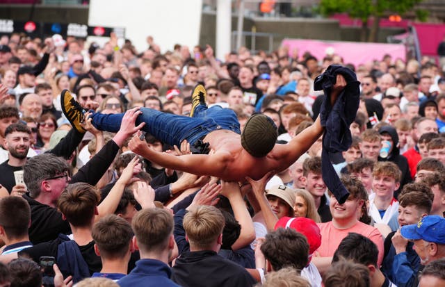 A man crowd-surfs shirtless after England equalise against Switzerland