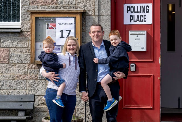 Scottish Conservative leader Douglas Ross and his wife holding their sons outside a polling station