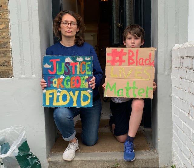 Handout photo taken with permission from the Twitter feed of @marisolly of Marisol Grandon, 41, and her son Oran Keith, 12, in Hackney, London who were among thousands of people across the UK to take a knee at 6pm on Wednesday evening in peaceful protest following the death of George Floyd