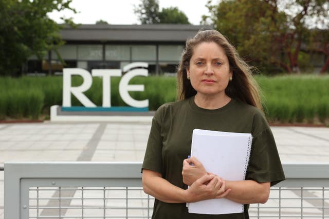 Emma O Kelly holding papers with external RTE sign in background