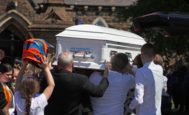 A coffin being carried into a church