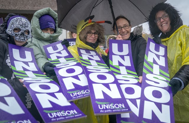 Staff holding Unison banners strike outside school