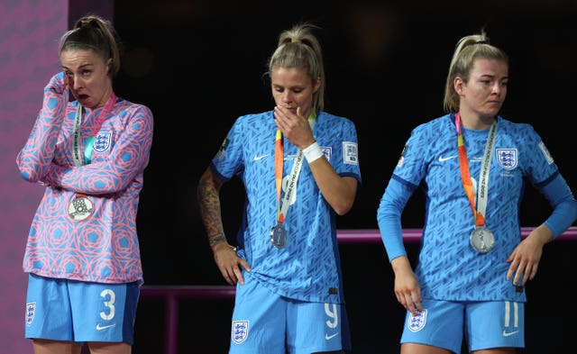 England’s Niamh Charles, Rachel Daly and Lauren Hemp, left to right, with their World Cup runners-up medals