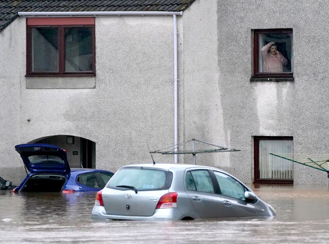 A person looks from a window at flood water in Brechin, Scotland