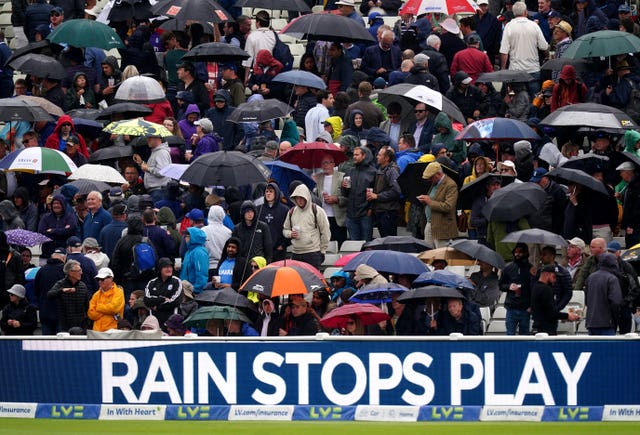Fans take shelter during a rain break at Edgbaston