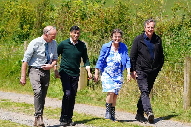 (left to right) Farmer David Chugg, Prime Minister Rishi Sunak, parliamentary candidate for North Devon Selaine Saxby and Foreign Secretary Lord David Cameron during a visit to a farm in Devon, while on the General Election campaign trail