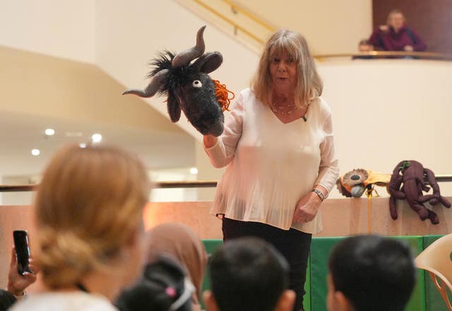 Julia Donaldson holding a character head while talking to children