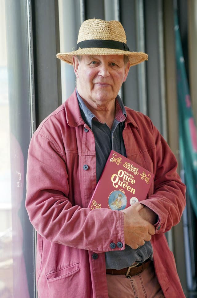 Michael Morpurgo stands holding his new book Once There is a Queen