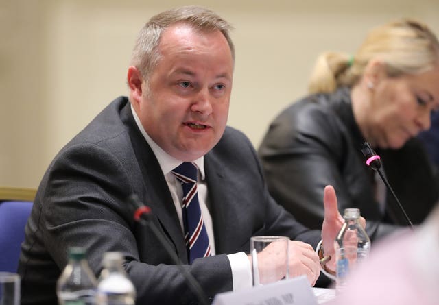 Head and shoulders photo of Darren Millar speaking, while seated