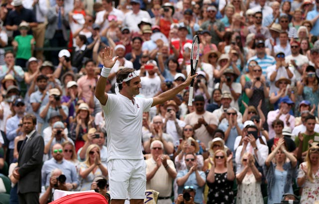 Roger Federer holds his fists aloft after beating Adrian Mannarino