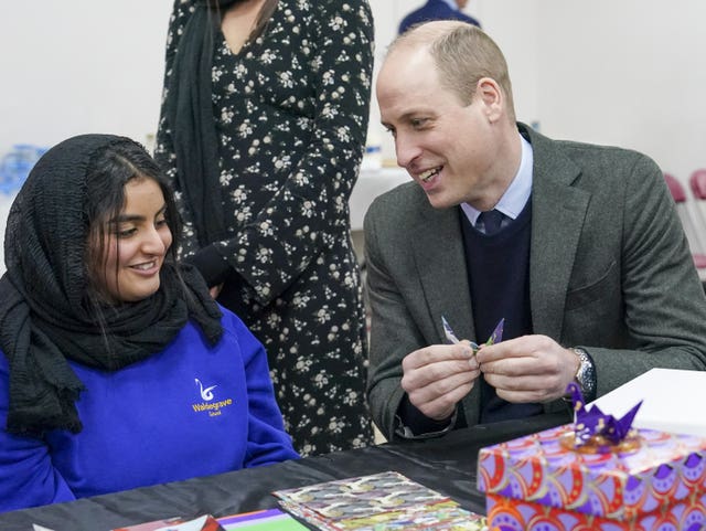 The Prince of Wales, makes a origami crane with Lina Alkutbi 15, one of two schoolgirls who made hundreds of origami cranes to raise funds for the Turkey-Syria Earthquake Appeal, during a visit to the Hayes Muslim Centre in west London