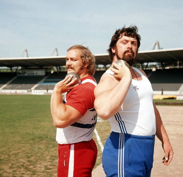 Al Feuerbach, left, and Geoff Capes, right, pose back to back with their shot puts