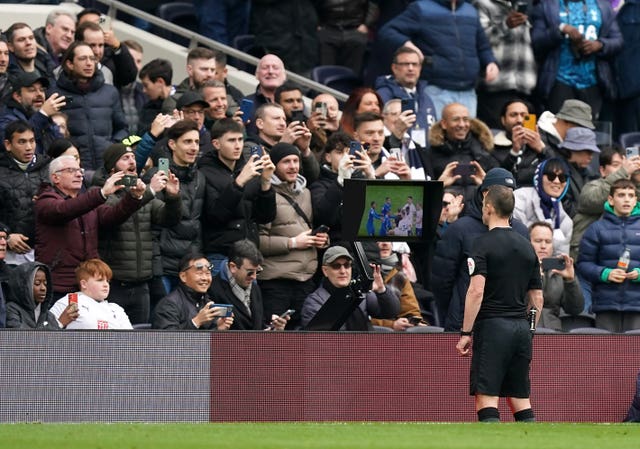 Referee Stuart Attwell checks the pitchside VAR monitor during the Tottenham v Chelsea match on February 26 