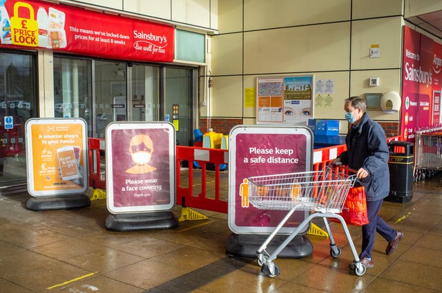 A shopper wearing a face mask outside a Sainsbury’s store