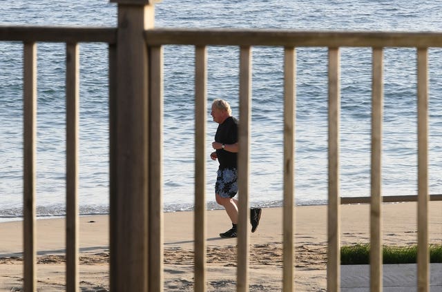 Prime Minister Boris Johnson takes an early morning run along the beach in Carbis Bay 