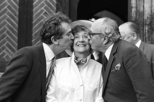 SDP president Shirley Williams receiving a kiss from fellow founding members of the party Bill Rodgers (left) and Lord Jenkins, outside the Church of St Edmunds following her wedding to American professor Richard Neustadt in 1987 