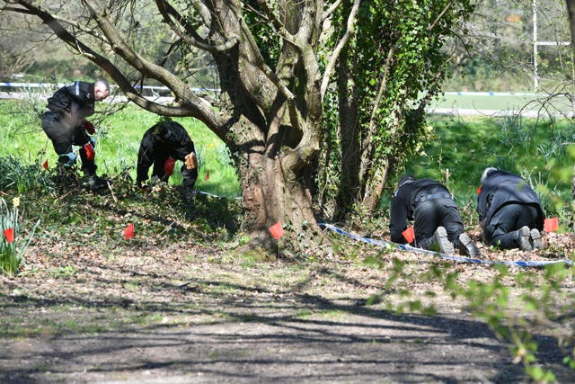 Police officers search the park