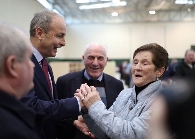 Fianna Fail leader Micheal Martin is greeted by a supporter during the Irish General Election count at the Nemo Rangers GAA Club in Cork