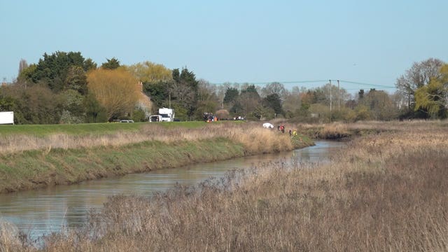 Emergency workers conducting searches after a car crashed into the Rive Nene