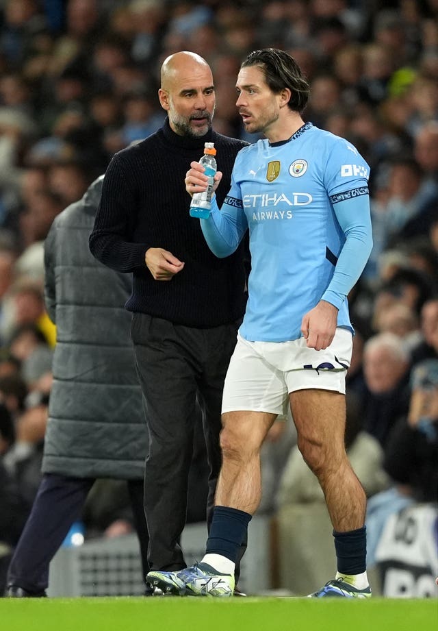 Pep Guardiola speaks to Jack Grealish as he prepares to come on as a substitute against Tottenham