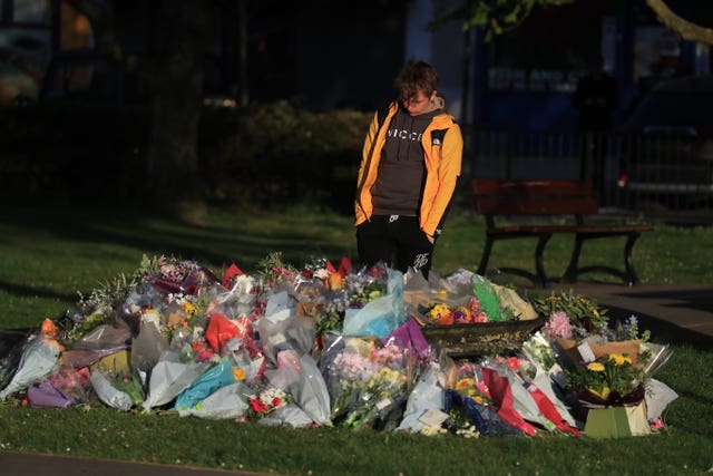Patrick James, the son of PCSO Julia James, looks at floral tributes left near her family home in Snowdown, near Aylesham, Kent 