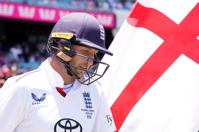 Joe Root walks out to bat next to an English flag.