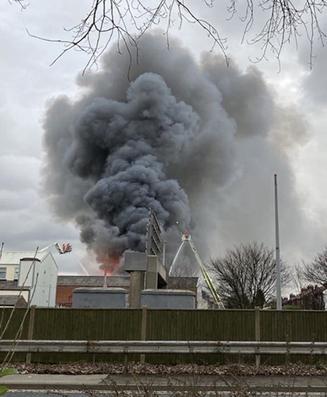 Smoke rises from a fire at a three-storey warehouse in Holland Street, Denton