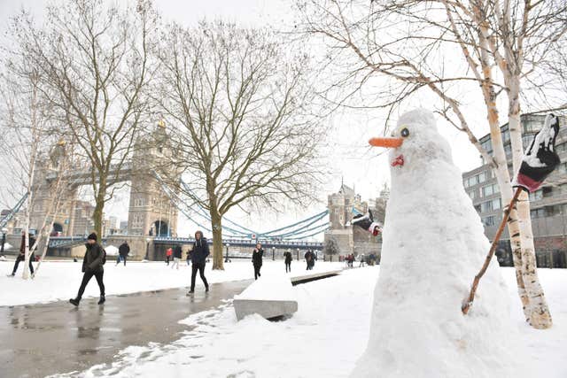 People walking in the snow by Tower Bridge were greeted by a snowman (Victoria Jones/PA)