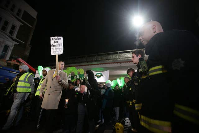 People pass firefighters paying their respects as they take part in a silent walk to mark the six month anniversary of the Grenfell Tower fire (Yui Mok/PA)