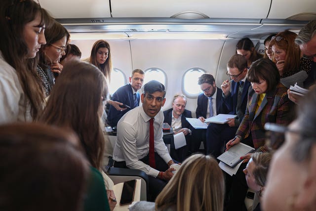 Prime Minister Rishi Sunak speaks to journalists on board a plane on his way to Warsaw 
