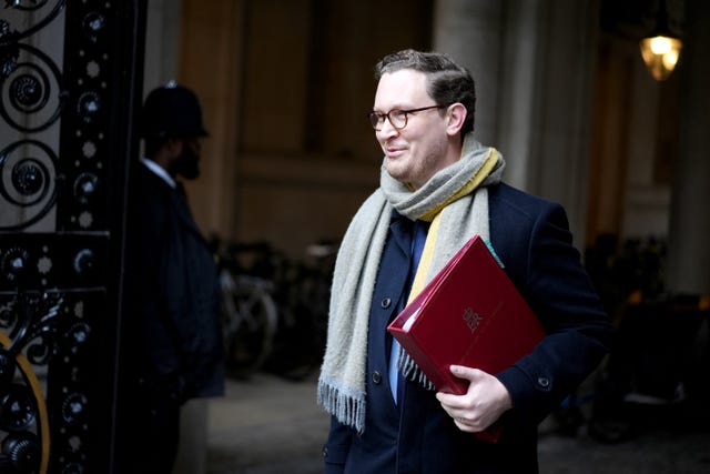 Darren Jones walking with a red folder