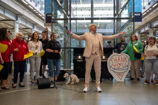 Tony Christie, centre, and Vicky McClure, centre left in white shirt, singing with the Our Dementia Choir and commuters at St Pancras railway station in London in July