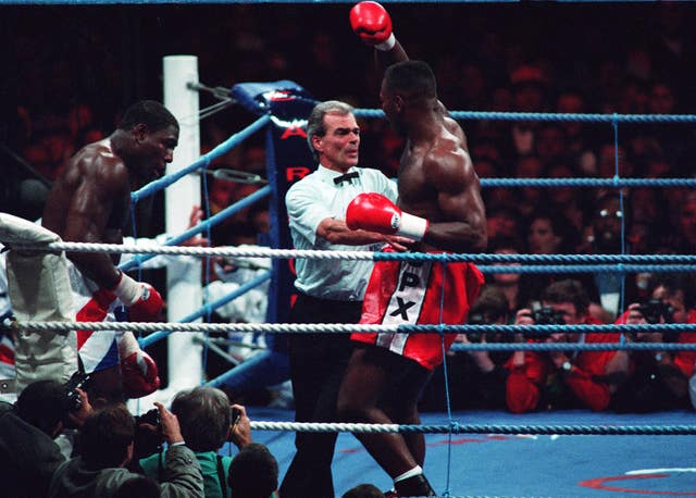 Frank Bruno slumps against the ropes as Lennox Lewis completes a seventh-round stoppage win in 1993