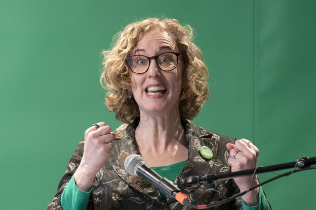 Lorna Slater clenching both her fists while animatedly speaking into a microphone