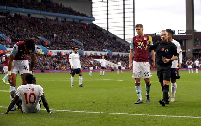 Referee Jon Moss shows Sadio Mane a yellow card for diving