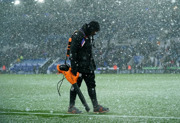 A member of Leicester's ground staff uses a leaf blower to clear the lines at the King Power Stadium