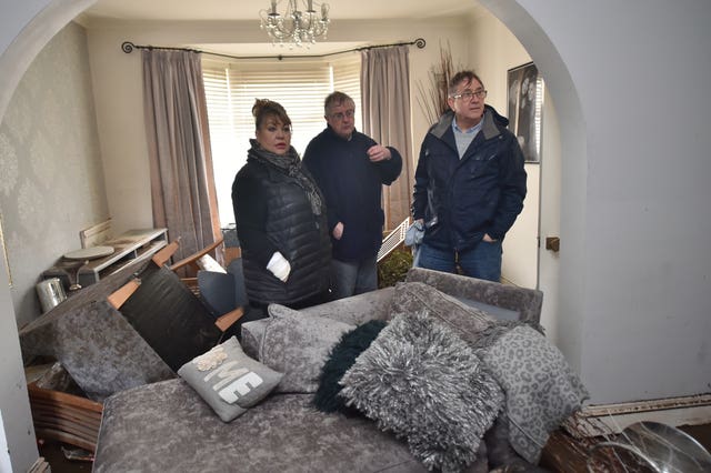 Welsh First Minister Mark Drakeford (centre) and Pontypridd AM Mick Antoniw (right) see the damage to resident Caroline Jones's home in Nantgarw (Ben Birchall/PA).