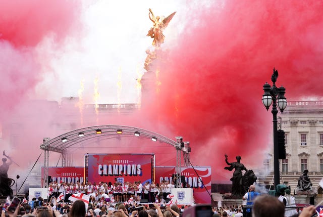 England players celebrate on stage as pyrotechnics are set off
